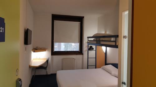 a bedroom with a bed and a desk and a bunk bed at Kyriad Direct Montauban Centre in Montauban