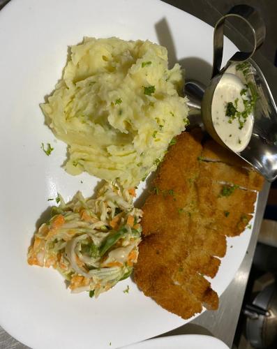 a plate of food with potatoes and coleslaw at Marion Roos Hotel in Puerto Galera