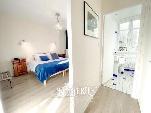 a bedroom with a bed with a blue comforter at La Domerie - Maison d'hôtes in Aubrac