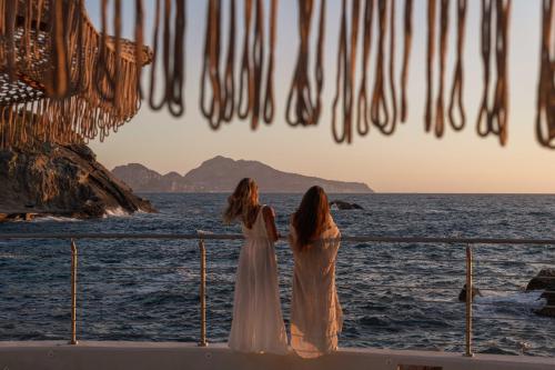 馬薩盧布倫塞的住宿－Maya Beach Resort，两个女人站在一艘眺望海洋的船上