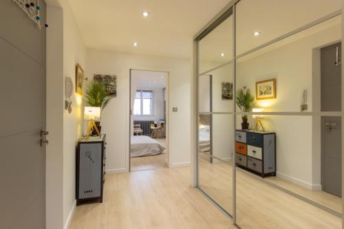 a large mirror in a room with a bedroom at Le Victor Hugo Appartement T3 proche Musée Soulages in Rodez