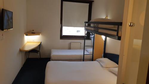 a room with two bunk beds and a desk at Kyriad Direct Montauban Centre in Montauban