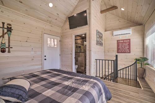 a bedroom with a bed in a room with wooden walls at Peaceful Cookeville Cabin on 52 Acres! in Cookeville
