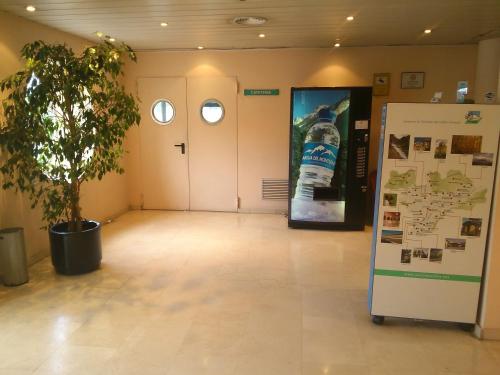 a large room with a plant and a refrigerator at Hotel Montmeló in Montmeló