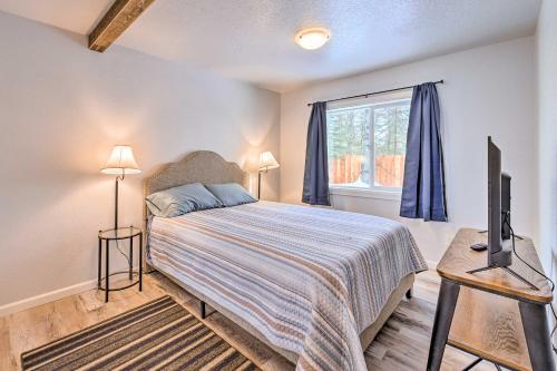 a bedroom with a bed and a tv and a window at Kenai Home with Fireplace Less Than 10 Mi to Big Eddy! in Kenai