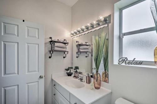 La salle de bains blanche est pourvue d'un lavabo et d'un miroir. dans l'établissement Pet-Friendly Palm Coast Home with Pool Table and Patio, à Palm Coast