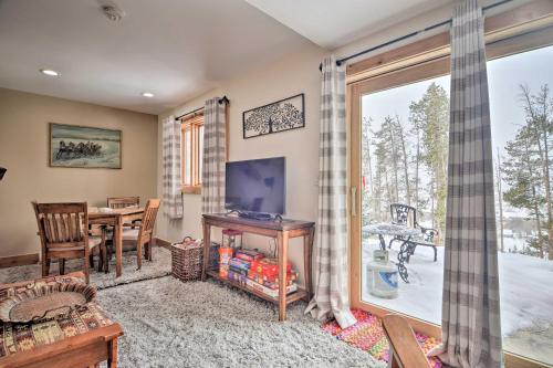 a living room with a table and a television and a window at Cozy Mountain Getaway with Ski Shuttle Access! in Fraser