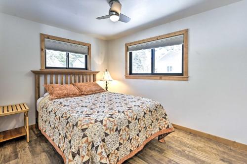 a bedroom with a bed and two windows at Happys Haven Cabin with Gas Grill and Fire Pit! in Lodi