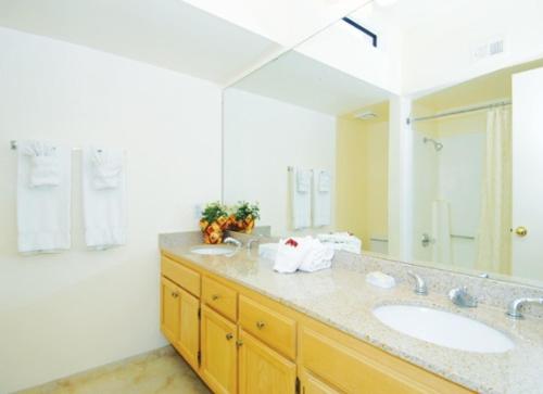 a bathroom with two sinks and a large mirror at GetAways at Vista Mirage Resort in Palm Springs