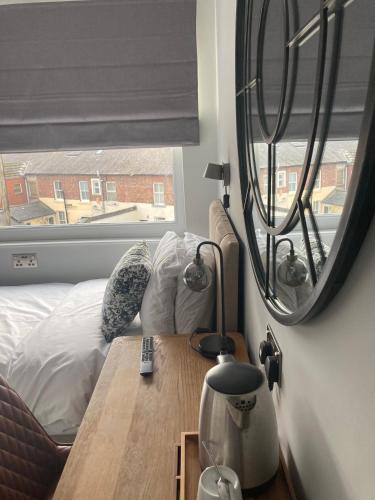 a bedroom with a bed and a mirror on the wall at Abbey Court Guest House in Carlisle