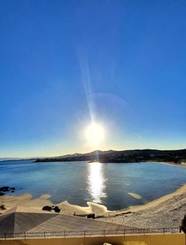 a view of a lake with the sun in the sky at Appartamento Delfino Bianco in Golfo Aranci
