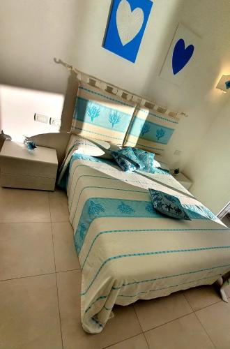 a bedroom with a bed with blue hearts on the wall at Appartamento Delfino Bianco in Golfo Aranci
