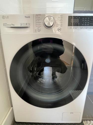a white washing machine with its door open at APPART 2P AVEC PARKING ET BALCON - gare val d'europe 5mn - disney 10mn in Montévrain