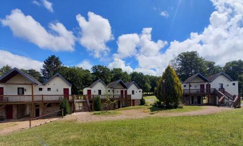 una fila de casas en un campo de hierba en Hôtel du golf du coiroux en Aubazines