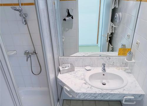 a bathroom with a sink and a shower at Hotel Restaurant Landluft in Aerzen