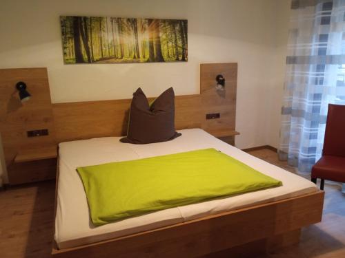 a bedroom with a bed with a green pillow on it at Gasthof Zum Löwen in Mespelbrunn