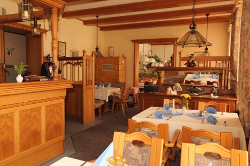ein Esszimmer mit 2 Tischen und eine Küche in der Unterkunft Hotel Kutzbach in Reuterstadt Stavenhagen