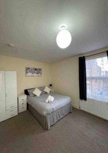 a bedroom with a bed and a large window at 4-5 Bedroom House For Corporate Stays in Kettering in Kettering