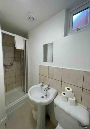 a bathroom with a sink and a toilet and a shower at 4-5 Bedroom House For Corporate Stays in Kettering in Kettering