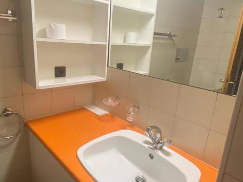 bagno con bancone arancione e lavandino di Residence kurtz a Maso Corto
