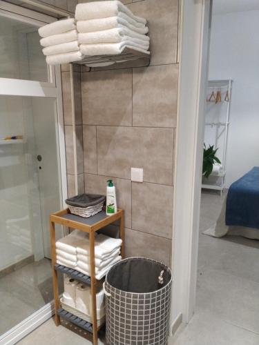 ein Badezimmer mit Handtüchern auf einem Regal und einem Korb in der Unterkunft Casa Guanche in Puerto del Rosario