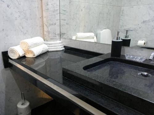 a bathroom with a sink and a tub with towels at Sleep In Bucelas in Bucelas