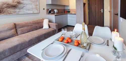 een woonkamer met een witte tafel en een bank bij Holiday Home Bel Mare 307e in Międzyzdroje