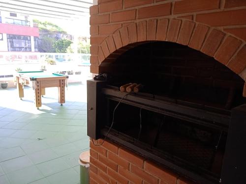 a brick oven with a table in the background at Cobertura Maravilhosa com área livre in Vitória