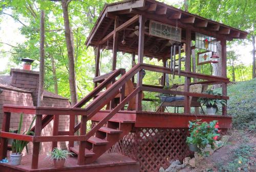 una casa en el árbol con terraza y escaleras en BENTON PLACE INN en Eureka Springs