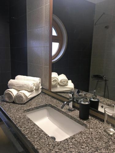 a bathroom with a sink and a mirror and towels at Sleep In Bucelas in Bucelas