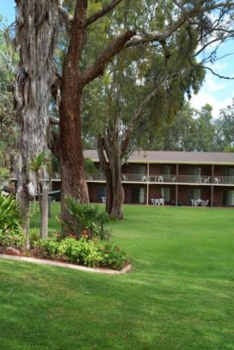 a large building with trees and a green yard at Tocumwal Golf Resort in Tocumwal