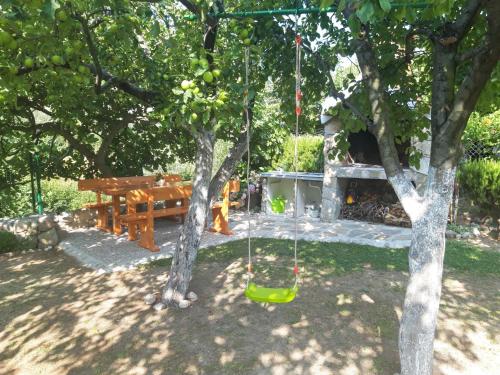 House next to the river Miro في Žrnovnica: أرجوحة معلقة من شجرة في الفناء