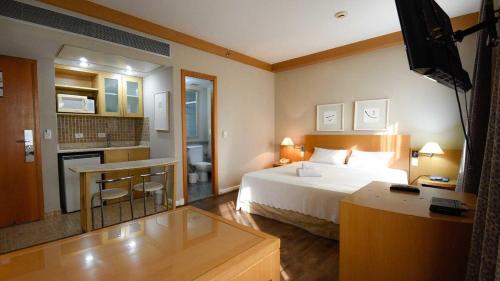 a hotel room with a bed and a kitchen at Flat 1208 Lazer completo - Prox. Shopping e Metrô in Sao Paulo