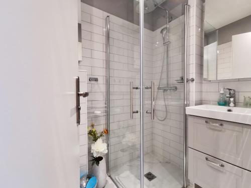 une salle de bain blanche avec une douche et un lavabo dans l'établissement Studio Royal Lux by Booking Guys, à Nice