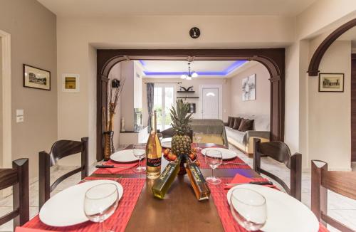 Kanelos Garden House في Dhrákas: غرفة طعام مع طاولة مع زجاجات النبيذ