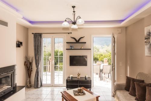 Kanelos Garden House في Dhrákas: غرفة معيشة مع أريكة وتلفزيون