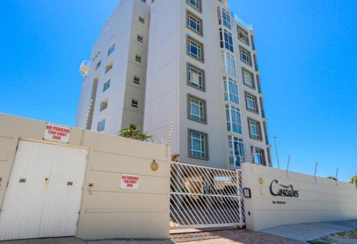 a tall white building with a fence in front of it at Cascades Self-Catering Apartments in Summerstrand
