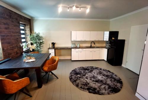 a kitchen with a table and chairs and a kitchen with white cabinets at Apart Oderblick in Neubleyen