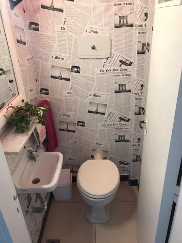 a bathroom with a toilet and a sink and a newspaper wall at Mira Bosques 3 in La Plata