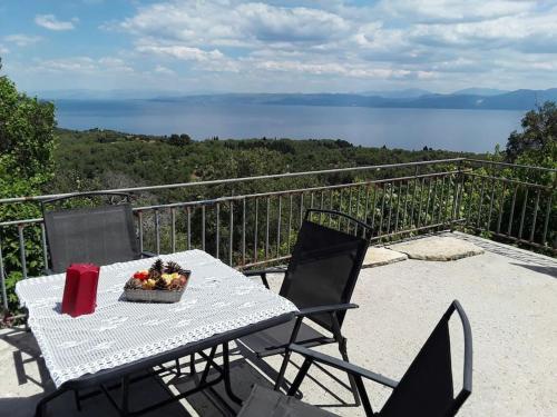 a table and chairs on a balcony with a view of the water at Cosy Studio with breathtaking view in Gaios