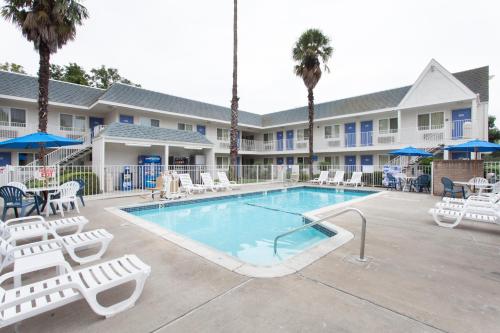 a swimming pool with lounge chairs and a resort at Motel 6-Sacramento, CA - Central in Sacramento