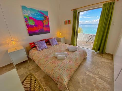 a bedroom with a bed with a view of the ocean at The Beachhouse Apartments in Vaia
