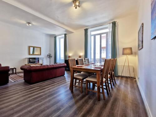 un salon avec une table, des chaises et un canapé dans l'établissement Congrès Carré d'Or by Booking Guys, à Nice