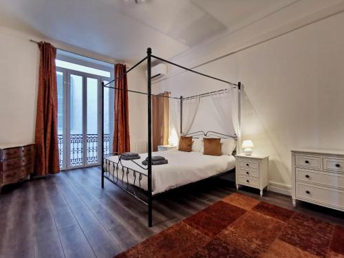 - une chambre avec un lit à baldaquin et un balcon dans l'établissement Congrès Carré d'Or by Booking Guys, à Nice