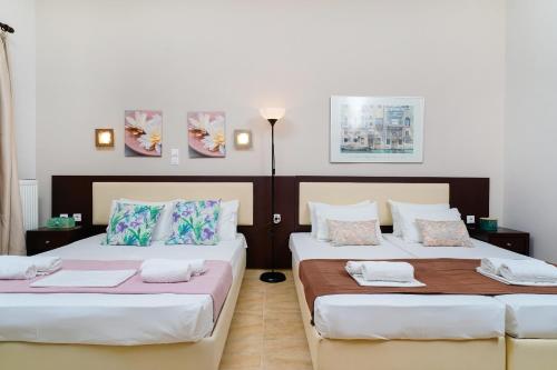 two beds in a room with white walls at Villa Yanna in Olympiada