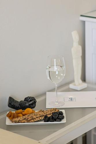a plate of food and a glass of wine on a counter at Hotel Grotta in Naxos Chora