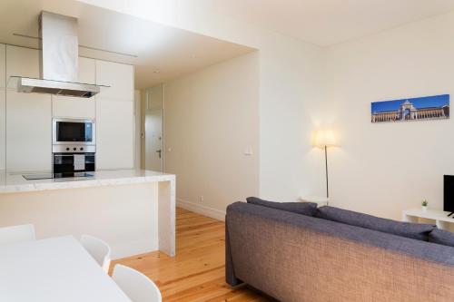 een woonkamer met een bank en een keuken bij Senhora do Monte Apartment 2(esq) with Outdoor Space in Lissabon