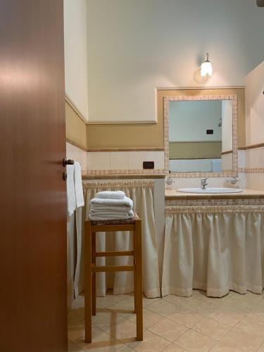 een badkamer met een wastafel en een tafel met handdoeken bij La casa di Giovanna in Lampedusa