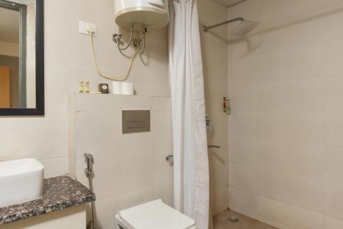 een badkamer met een douche, een toilet en een wastafel bij HIMALAYAN REGENCY Manali in Manāli