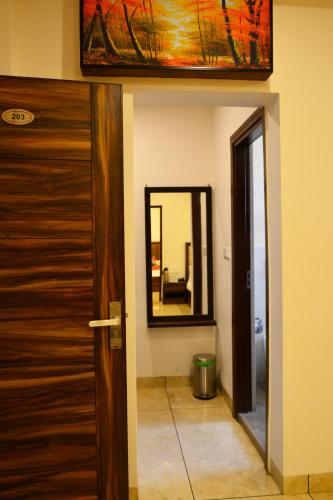 a door to a room with a mirror and a door sidx sidx sidx at SERENE SUITES in Dharamshala